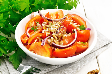 Image showing Salad with tomato and walnut in plate on light board