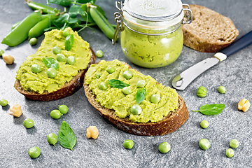 Image showing Sandwich green pea hummus on stone dark table