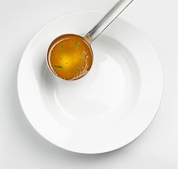 Image showing empty white soup plate and broth ladle 