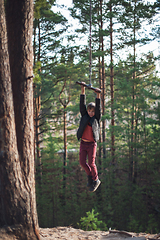 Image showing Teen boy at bungee in autumn forest