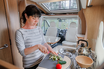 Image showing Woman cooking in camper, motorhome interior