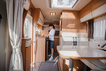 Image showing Woman cooking in camper, motorhome interior