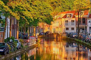 Image showing Delt canal with old houses and cars parked along on sunset