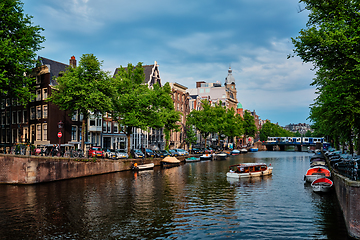 Image showing Amsterdam view - canal with boad, bridge and old houses