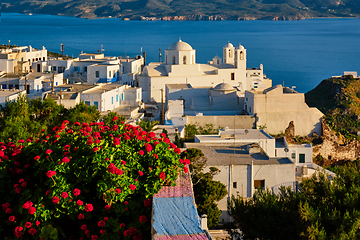 Image showing Picturesque scenic view of Greek town Plaka on Milos island over red geranium flowers