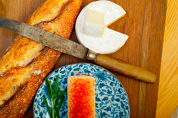 Image showing French cheese and fresh  baguette on a wood cutter