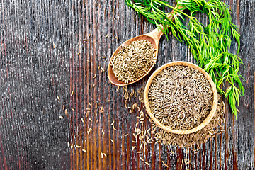 Image showing Cumin seeds in bowl and spoon with herbs on board top