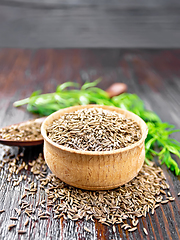 Image showing Cumin seeds in bowl and spoon with herbs on table