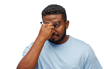 Image showing tired african man in lasses touching nose bridge