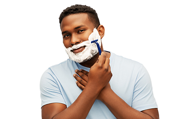 Image showing smiling african man shaving beard with razor blade