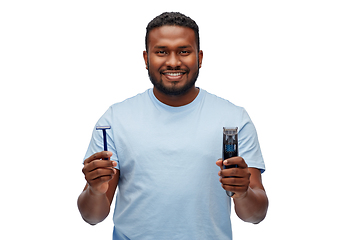 Image showing smiling african man with razor blade and trimmer