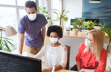 Image showing creative team in masks with computer at office
