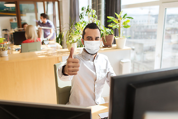 Image showing male office worker in mask showing thumbs up