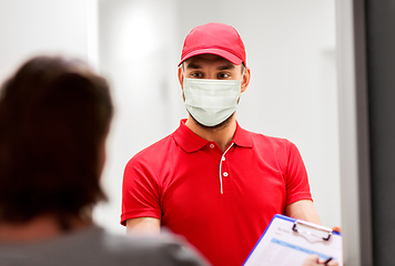 Image showing delivery man in mask and customer signing papers