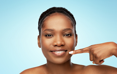 Image showing african american woman pointing to her mouth