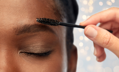 Image showing face of african woman and hand with mascara brush