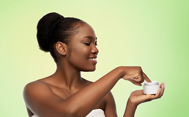 Image showing smiling african american woman with moisturizer