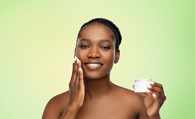 Image showing smiling african american woman with moisturizer