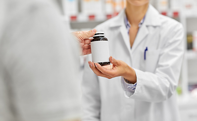 Image showing pharmacist and customer with medicine at pharmacy