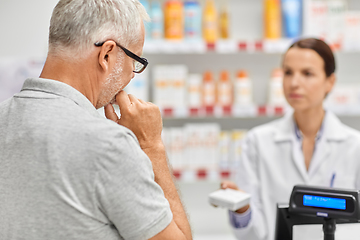 Image showing pharmacist and old man with medicine at pharmacy