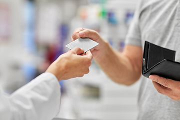 Image showing close up of hand giving bank card to pharmacist