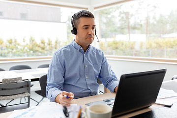 Image showing man with headset and laptop working at home