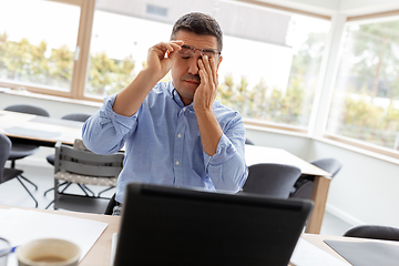 Image showing tired man with laptop working at home office