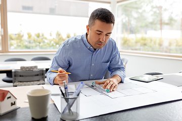 Image showing architect with blueprint working at home office