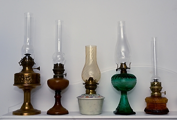 Image showing five vintage kerosene lamps on a shelf 