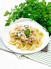 Image showing Pasta with salmon in cream on light wooden board