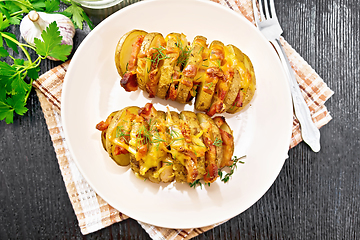 Image showing Potatoes with smoked bacon in plate on dark board top