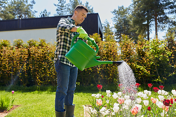 Image showing middle-aged man watering flowers at garden