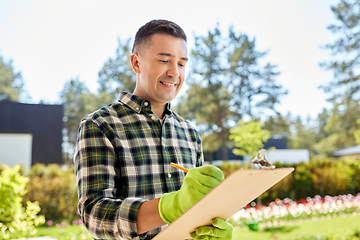 Image showing happy man with clipboard at summer garden