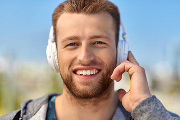 Image showing man in headphones listening to music outdoors