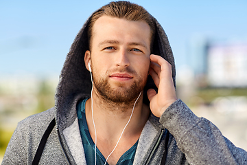 Image showing man in earphones listening to music outdoors