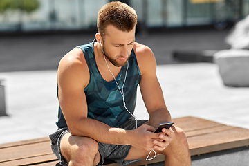 Image showing young athlete man with earphones and smartphone