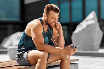 Image showing young athlete man with earphones and smartphone