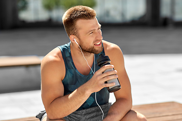 Image showing sportsman with earphones and bottle in city