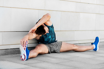 Image showing man doing sports and stretching outdoors