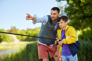 Image showing happy smiling father and son fishing on river