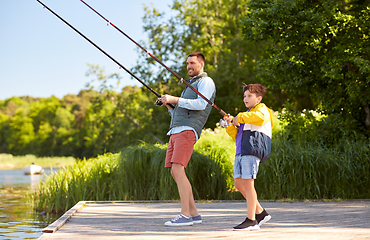 Image showing happy smiling father and son fishing on river