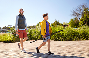 Image showing happy smiling father and son fishing on river