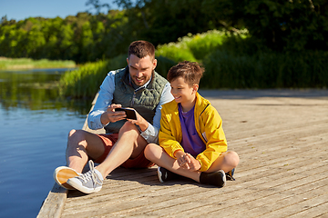 Image showing father and son with smartphone on river berth