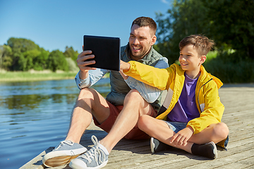 Image showing happy father and son with tablet pc on river berth