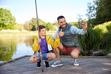 Image showing father and son with fishing rods taking selfie