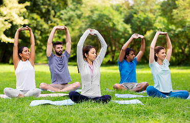 Image showing group of happy people doing yoga at summer park