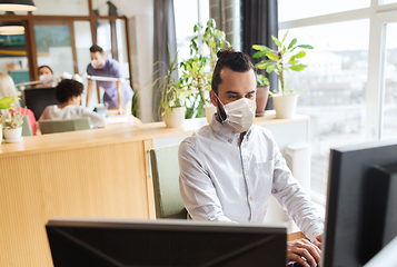 Image showing creative male office worker in mask with computer