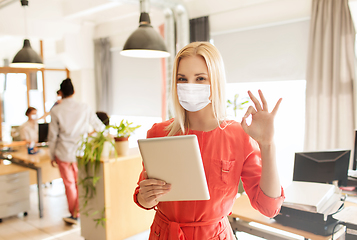 Image showing woman in mask with tablet pc showing ok at office