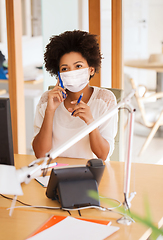 Image showing businesswoman in mask calling on phone at office