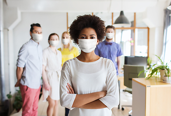 Image showing woman in mask over creative team at office